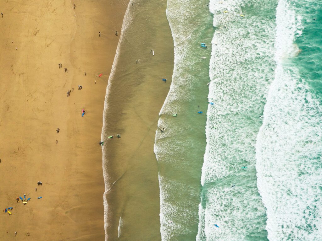 An aerial view of surfers on a beach at Newquay
