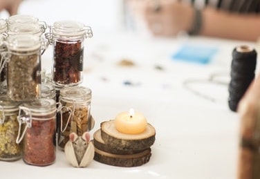 Glass spell jars and a tea candle on a table