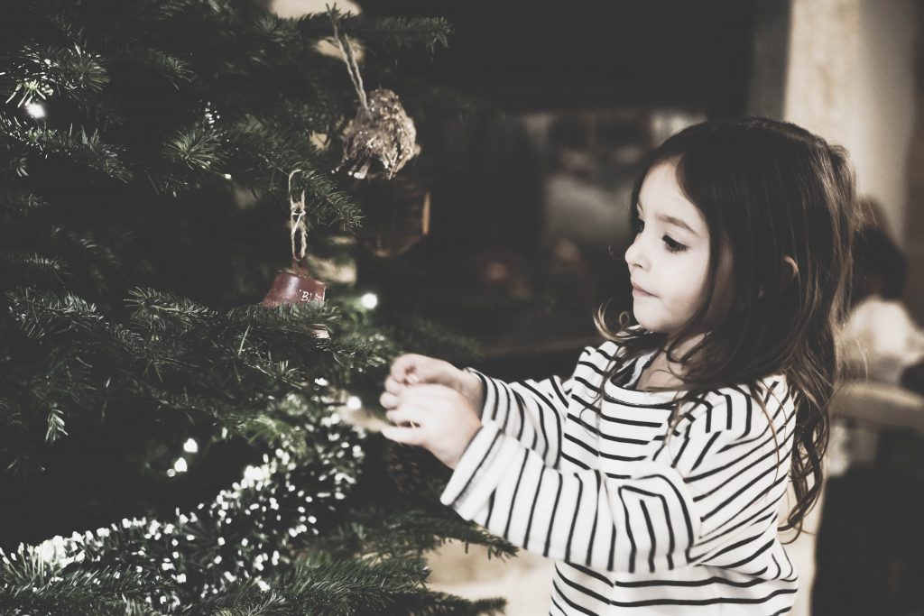 A young girl decorating a tree
