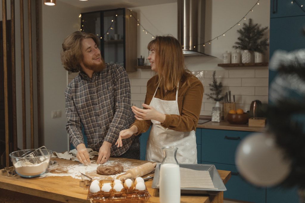 Two people in a kitchen making festive cookies
