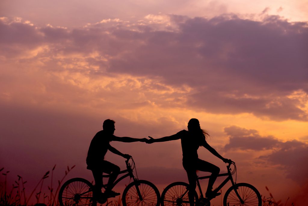 A couple on a bike ride in the sunset