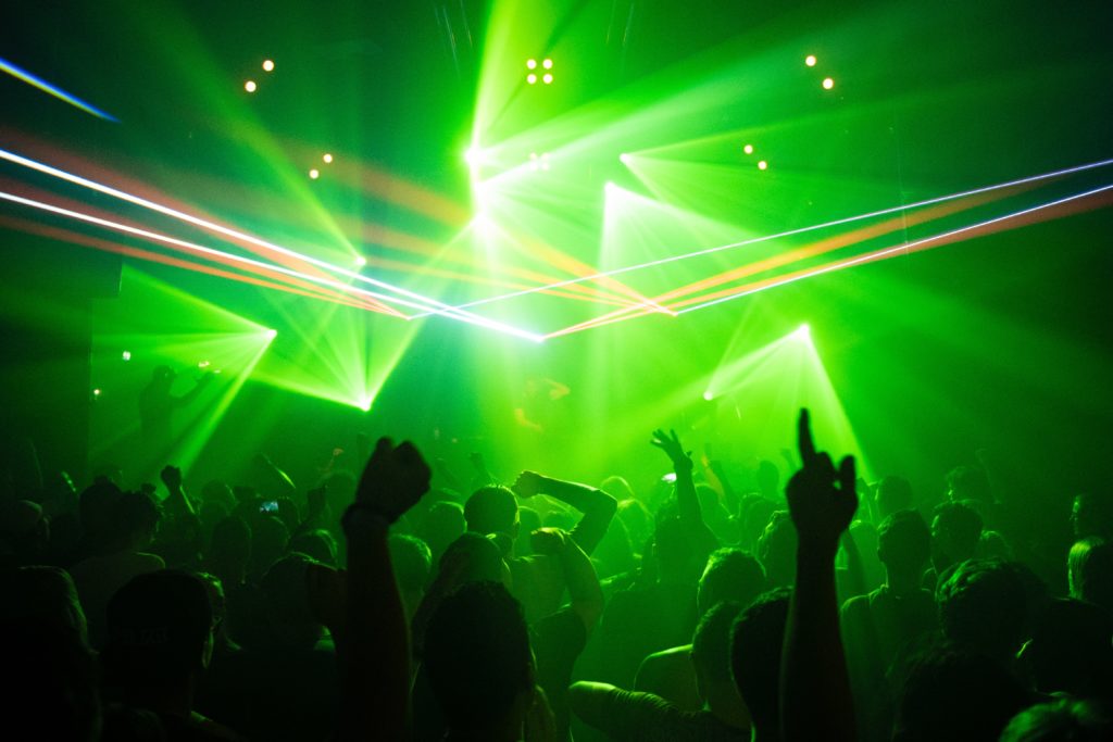 People dancing in a nightclub with green lights